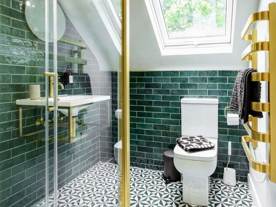 Green-tiled bathroom with brass fittings and patterned floor